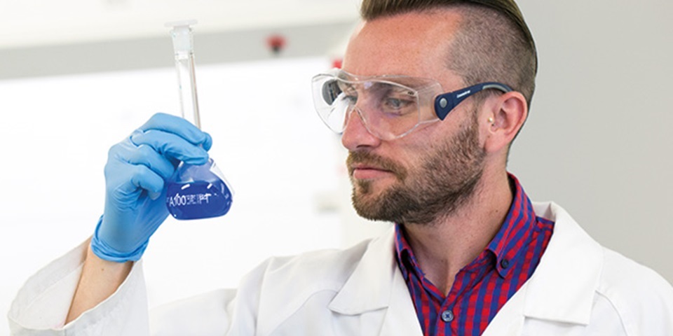 Researcher looking at lab glassware