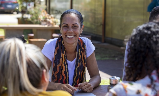 Aboriginal woman at table with other students