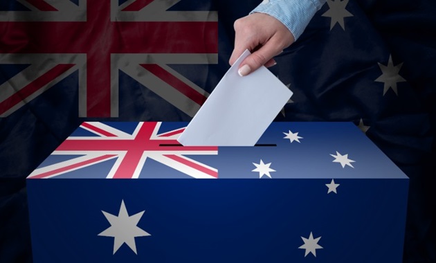 Vote is place in a ballot box decorated with Australian flag with flag in background