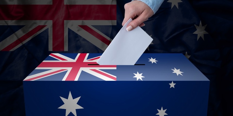 Vote is place in a ballot box decorated with Australian flag with flag in background