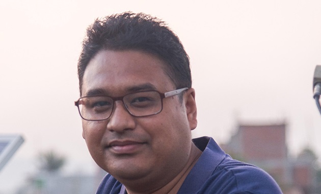 Murdoch alumnus Avishek Malla smiling at camera with solar panel in background