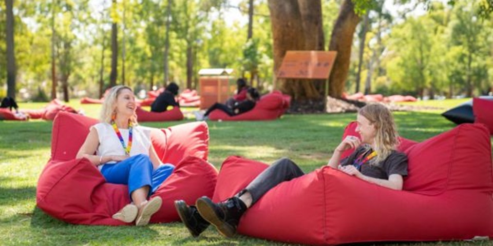 Murdoch alumnus and staff member chatting on bush court