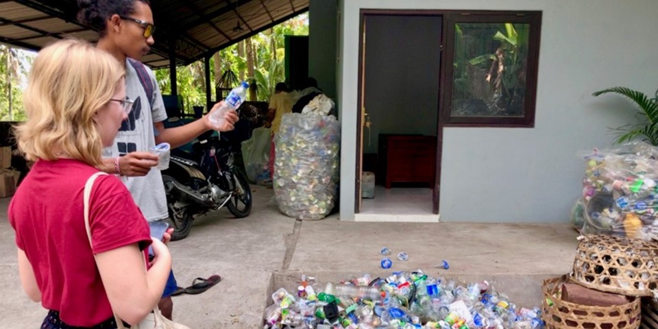 people looking at empty plastic bottles for recycling