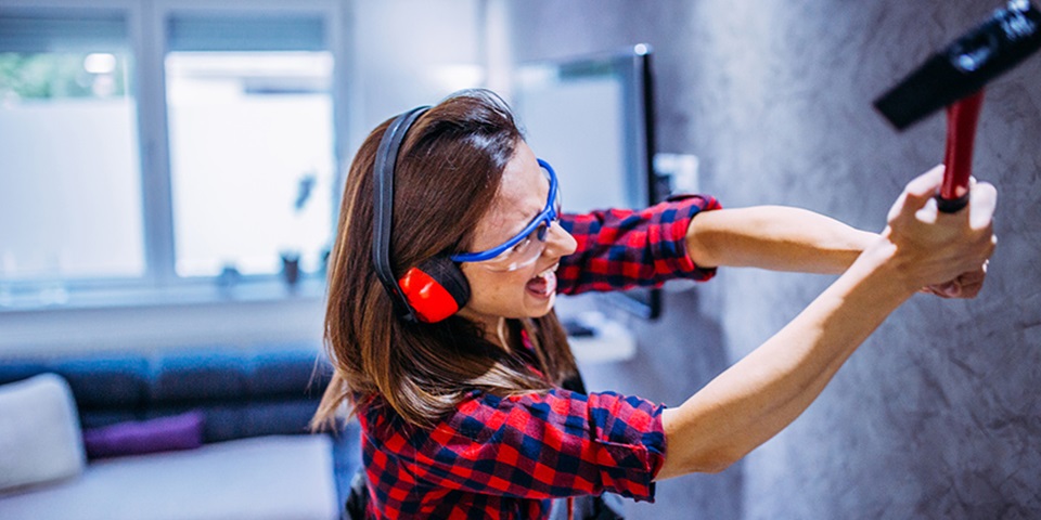 Woman smashing wall with tool