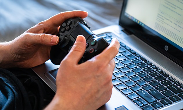 Child using video game handset with computer