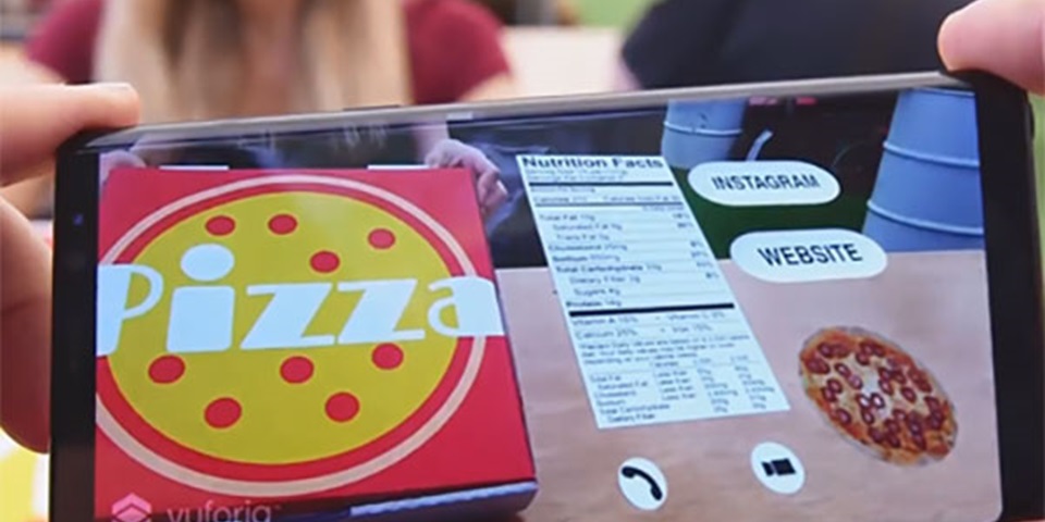 Fingers holding a smartphone which shows augmented reality information about a pizza