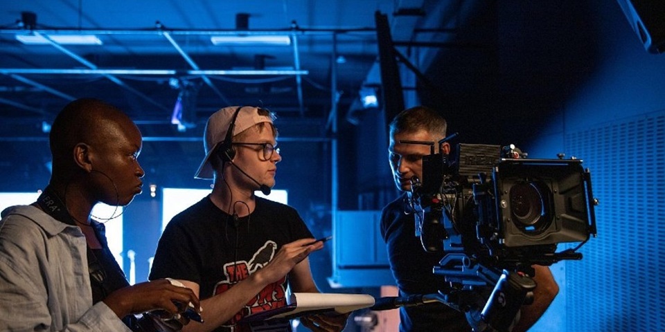 Students look through video camera in a studio