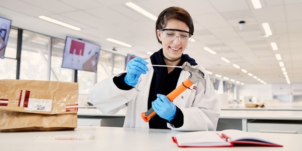 Student swabs hammer in a science lab