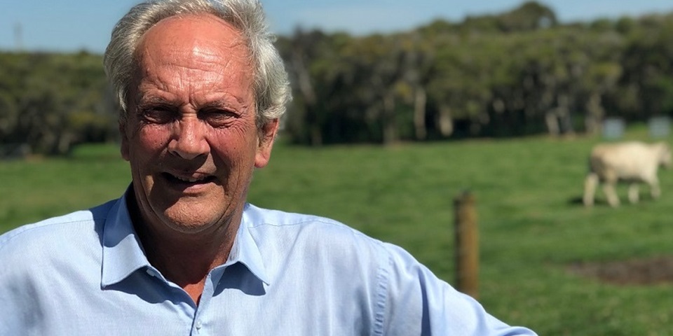 Professor David Pethick standing by a farm gate with cow in the background