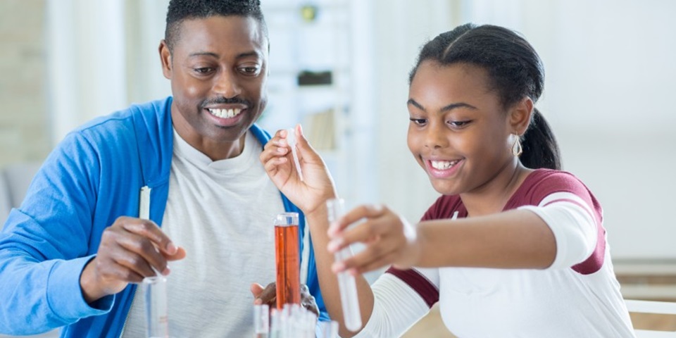 Father and daughter conducting science experiments at home