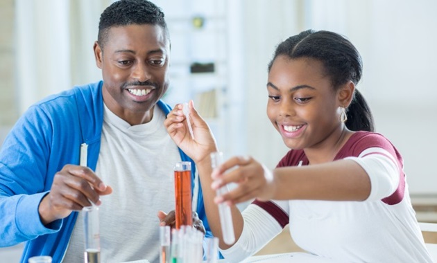 Father and daughter conducting science experiments at home