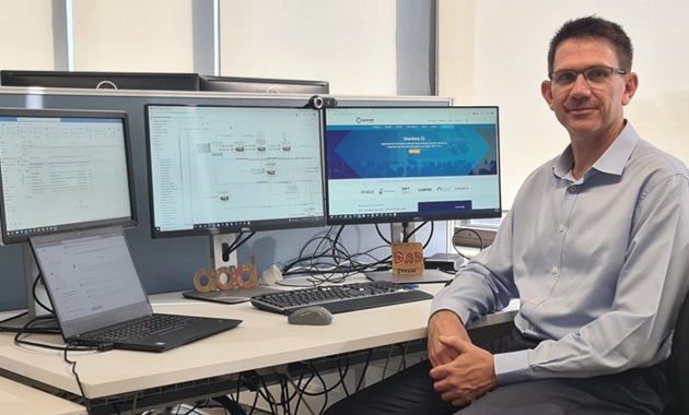 Russell Dunstan sitting in front of computer looking at camera