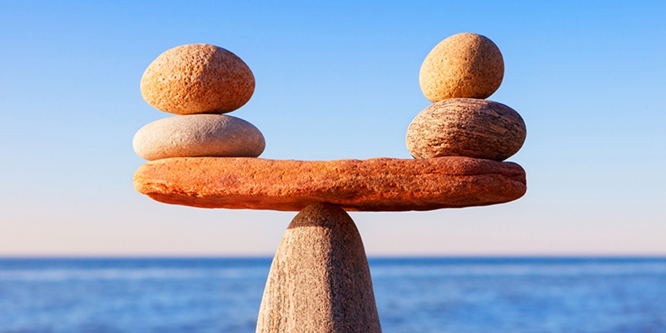 Pebbles balancing against an ocean backdrop