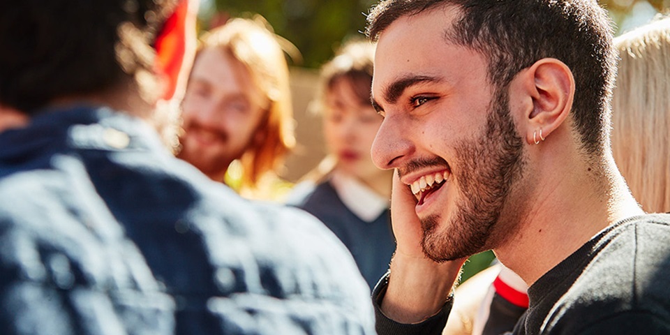 Student sitting at table with friends and smiling