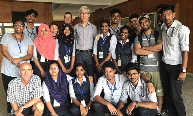 Group of students and lecturers posing and smiling