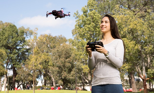 Female student flies drone outside.