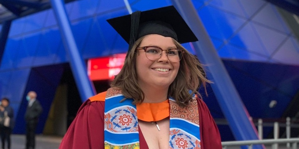 Recent Kulbardi and Murdoch graduate, Sasha Ihms smiling at the camera in front of RAC Arena.