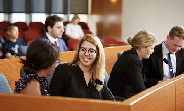 Lawyers speak to each other in a court room.