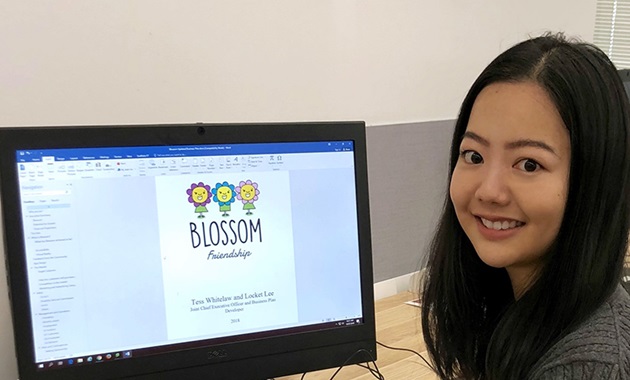 Student Locket Lee sitting in front of the computer smiling at camera