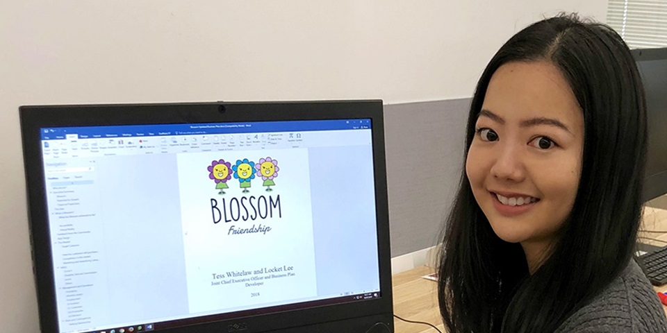 Student Locket Lee sitting in front of the computer smiling at camera