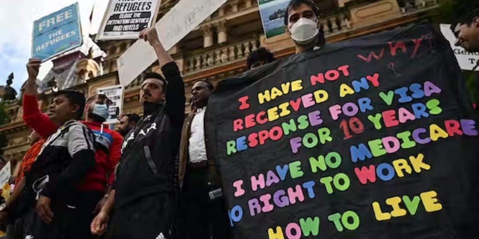 Refugee protestors holding signs that demand action for visas