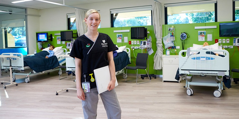 A Murdoch  University nursing student stands in the simulated ward