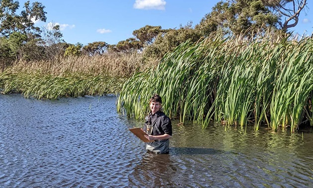 Jemma Goss standing in the middle of swamp water