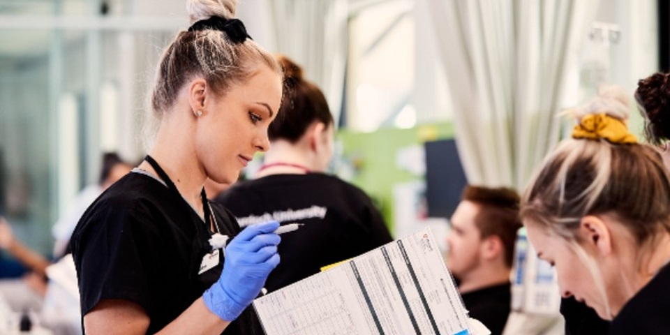 Female nursing looking at patients file