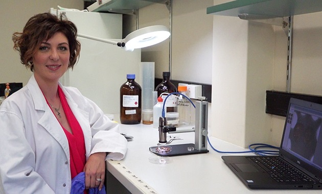 dr paola magni with a microscrope in a lab