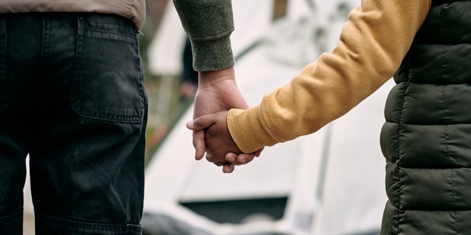 Parent and child holding hands - refugee and asylum seekers