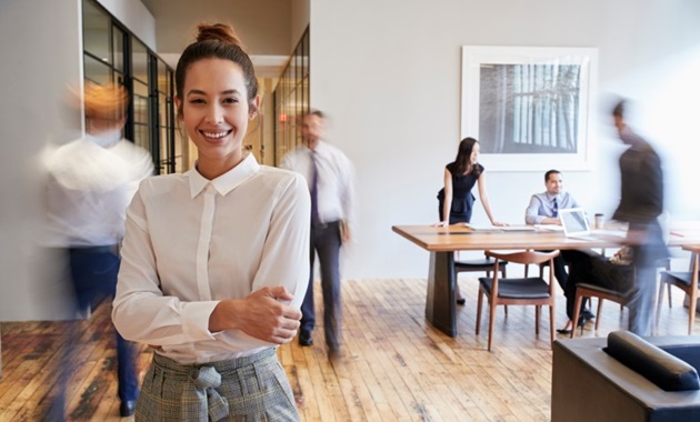 Professional woman smiling in a busy office