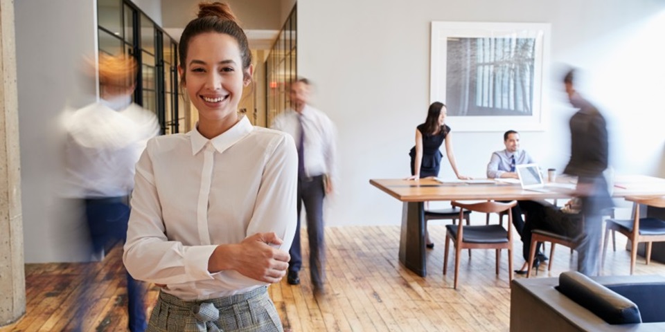 Professional woman smiling in a busy office