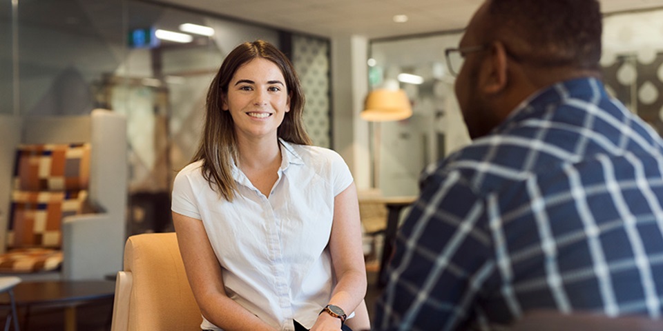 Female student smiles sitting in psychology clinic.