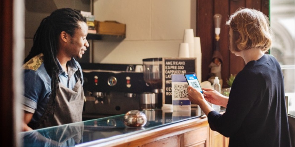 woman scanning qr code in cafe