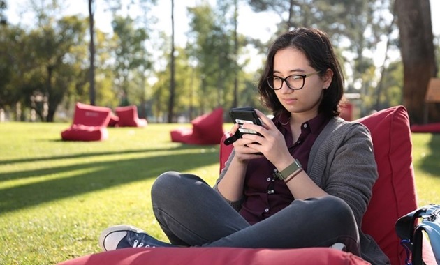 Teenager sitting outside by themselves on their phone