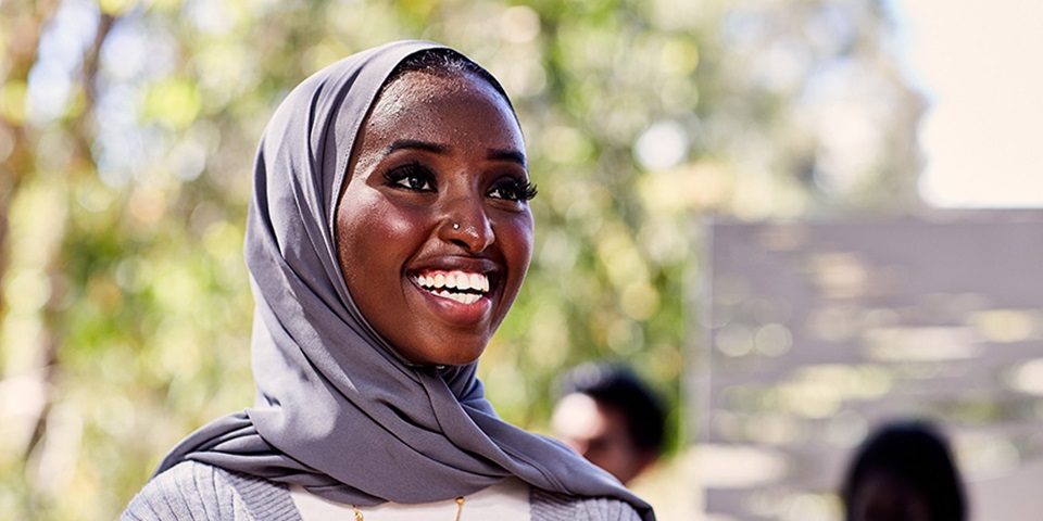 Female student wearing hijab smiling.