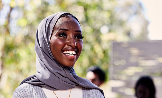 Female student wearing hijab smiling.