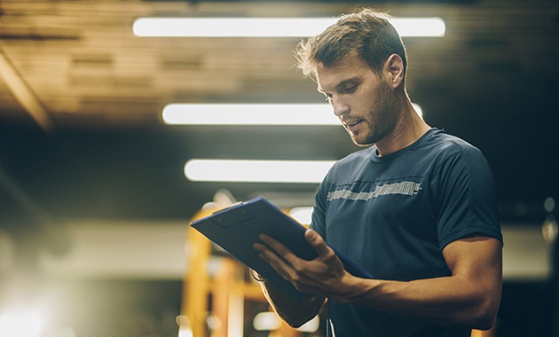 Strength and conditioning coach assessing training in the gym