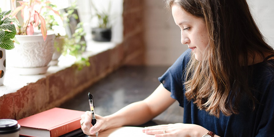 Girl studying and writing notes in a cafe