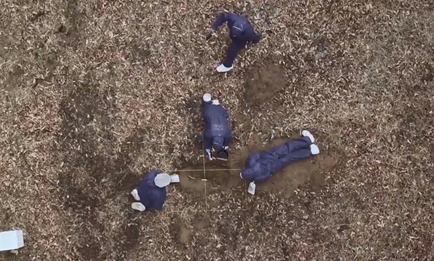 birds eye view of students excavating grave