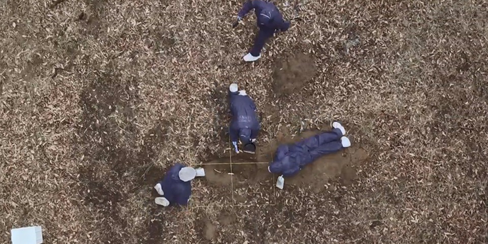 birds eye view of students excavating grave