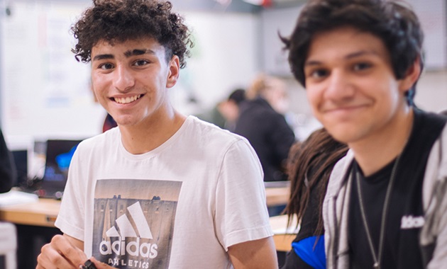 Two teenage boys sitting in a classroom