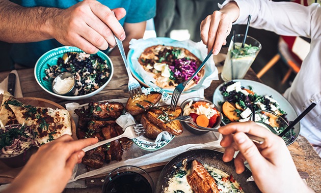 Friends gathered around a table with vibrant food