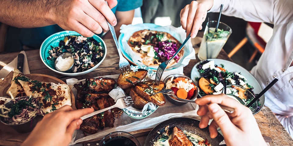 Friends gathered around a table with vibrant food