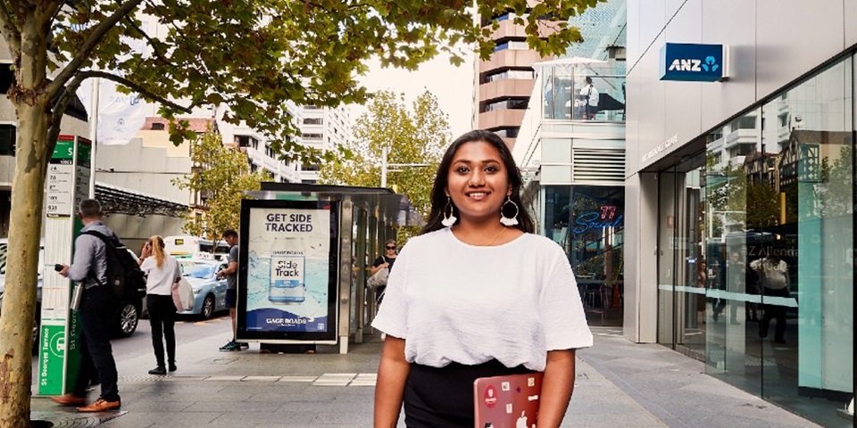 Female student standing in the middle of St Georges Terrace in Perth