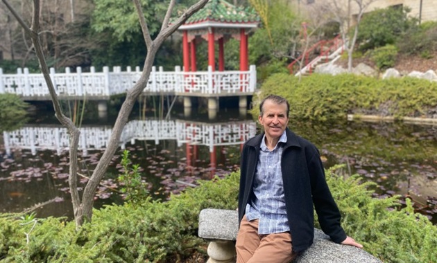 Warren sitting at the Chinese Gardens on Murdoch Campus