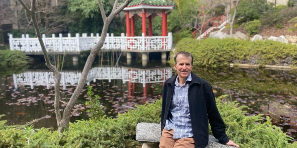 Warren sitting at the Chinese Gardens on Murdoch Campus