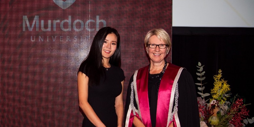 Wenna Lee and Vice Chancellor Eeva Leinonen stand in front of a banner at the VC awards