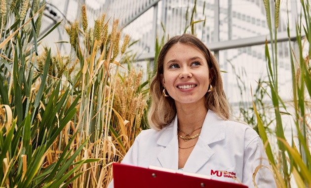 Murdoch student standing among crops